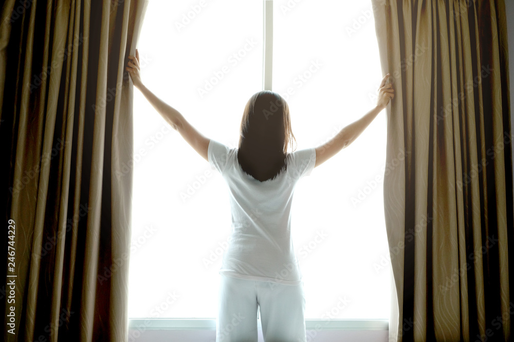 Morning of a new day, alarm clock wake up man sitting in the room. A man stretch the muscles at window. Health and care concepts Morning of a new day, alarm clock wake up man sitting in the room. A man stretch the muscles at window. Health and care concepts
