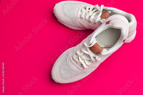 Pair of sneakers on red background, flat lay