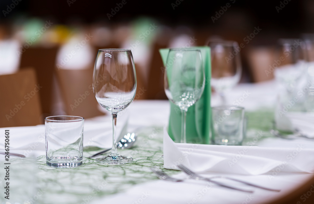 Decorated table on a gala dinner party with wine glasses and blurred out background Decorated table on a gala dinner party with wine glasses and blurred out background