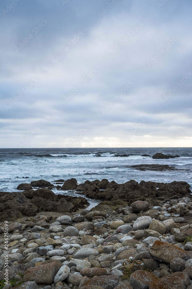 Ocean waves crashing on rocks, coastline view in California. Sand and rocks on a beach Ocean waves crashing on rocks, coastline view in California. Sand and rocks on a beach