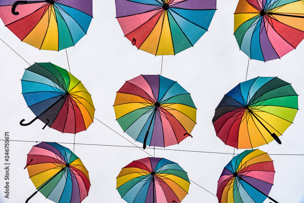 Rows of rainbow colored umbrellas hanging in the air