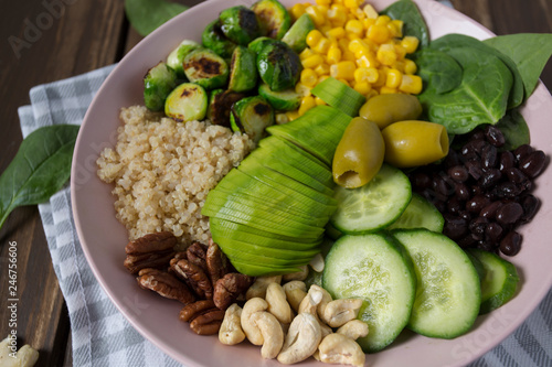 budha bowl with brussel cabbage  corn  quinoa  cucumbers nuts  avocado and spinach
