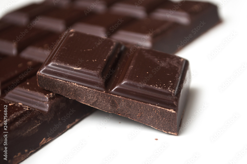 closeup of milk chocolate blocks on white background closeup of milk chocolate blocks on white background