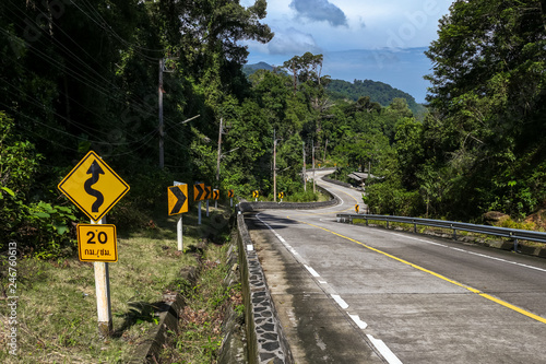 Koh Phangan, Thailand - December 19, 2018: Curvy road winding through beautiful jungle and coconut palm trees in Koh Phangan tropical island, a popular full moon party destination in Thailand