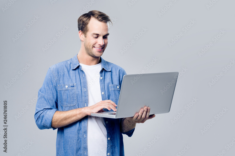 Smiling young man working with laptop