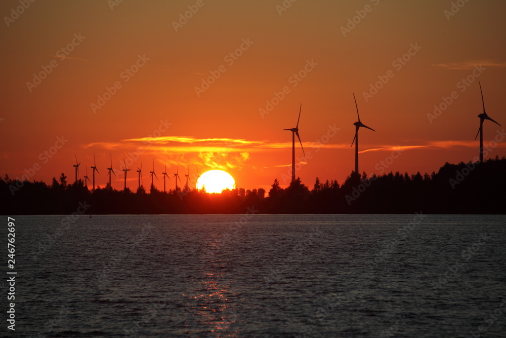 Naklejka premium coucher de soleil sur un parc d'éoliennes 