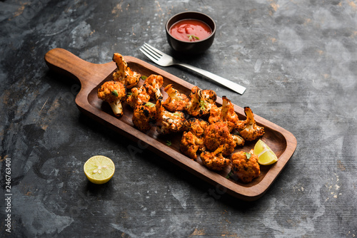 Tandoori Gobi / Roasted cauliflower Tikka is a dry dish made by roasting Cauliflowers in Oven/Tandoor. It's popular starter food from India. served with ketchup. selective focus