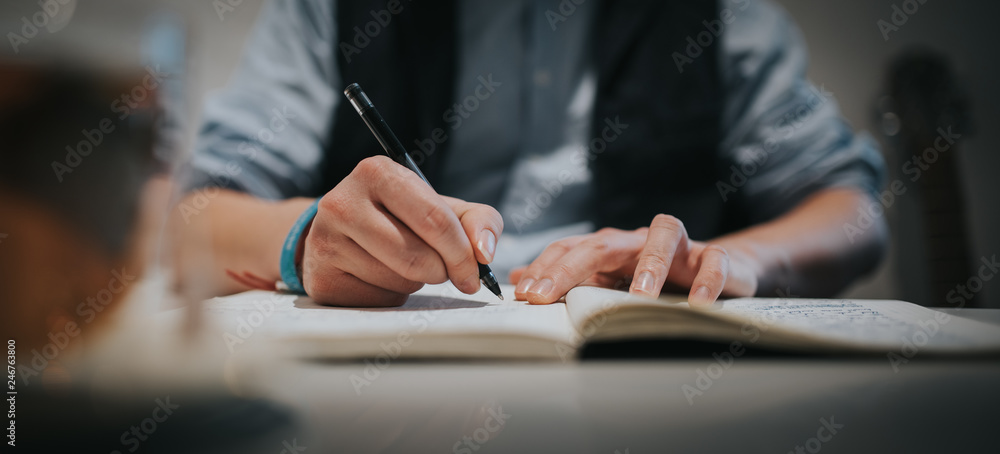 Schriftsteller, Mann schreibt Text auf Papier in ein Buch Schriftsteller, Mann schreibt Text auf Papier in ein Buch
