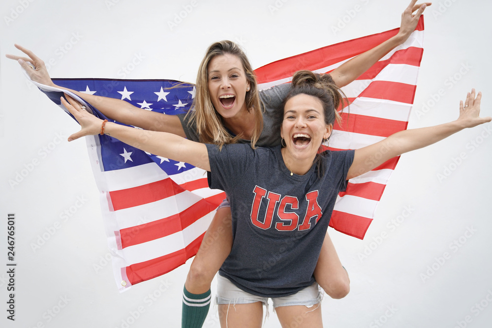 Fototapeta premium Energetic young friends proudly flying American flag on white background
