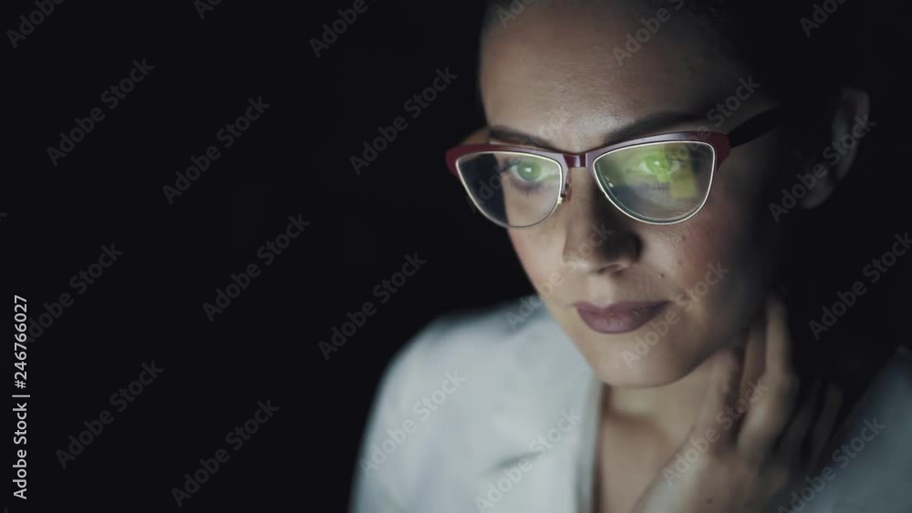 reflection of a working monitor with glasses. business woman working on a computer in the dark reflection of a working monitor with glasses. business woman working on a computer in the dark