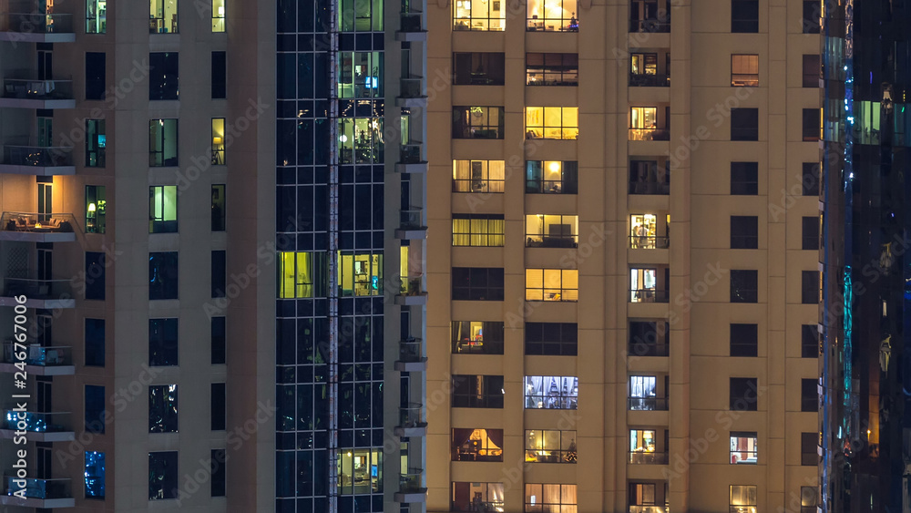 Glowing windows in multistory modern glass and metal residential building light up at night timelapse. Glowing windows in multistory modern glass and metal residential building light up at night timelapse.