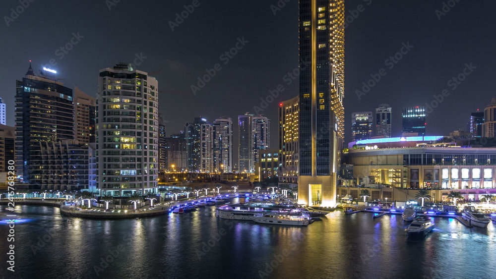 Aerial vew of Dubai Marina with shoping mall, restaurants, towers and yachts night timelapse, United Arab Emirates. Aerial vew of Dubai Marina with shoping mall, restaurants, towers and yachts night timelapse, United Arab Emirates.