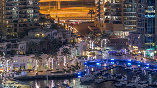Photography Luxury Dubai Marina canal with passing boats and promenade night timelapse, Duba