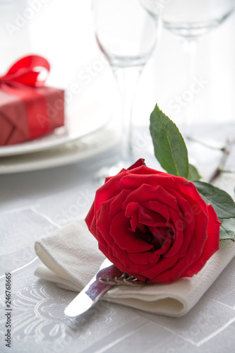 Festive or romantic dinner with red rose and gift. Romantic invitation