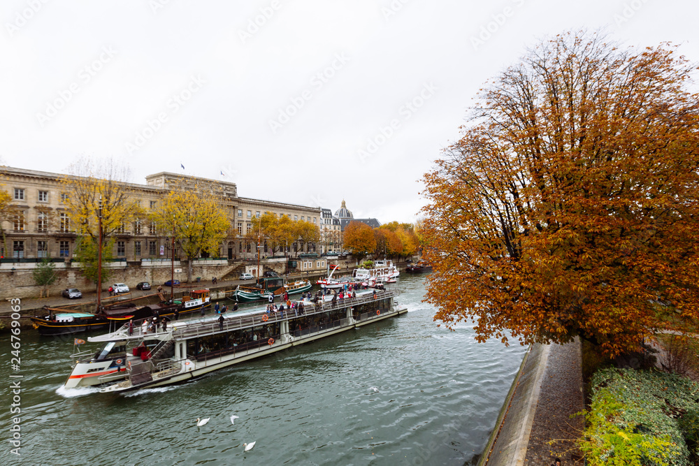 Paris (France) - Walking along the river Seine in a winter day, bateaux mouche in navigation