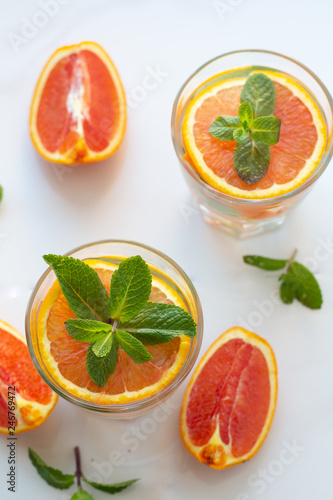 drink with red orange and mint and orange slices on a white background top view.
