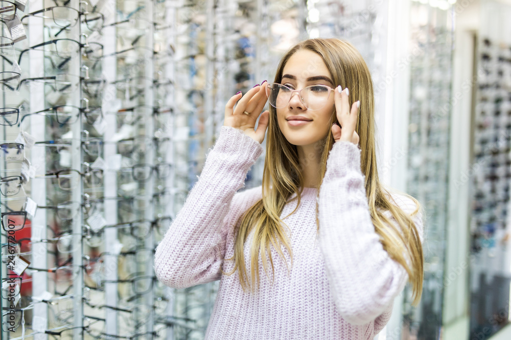 Portrait of happy young woman buying new glasses at optician store Portrait of happy young woman buying new glasses at optician store