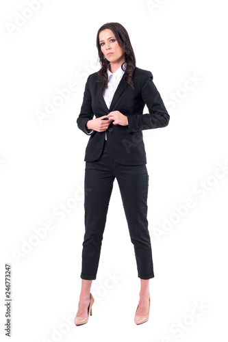 Serious confident corporate woman buttoning suit preparing for work. Full body isolated on white background. 