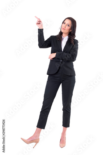 Confident business woman presenting with finger pointing up at copy space looking at camera. Full body isolated on white background. 