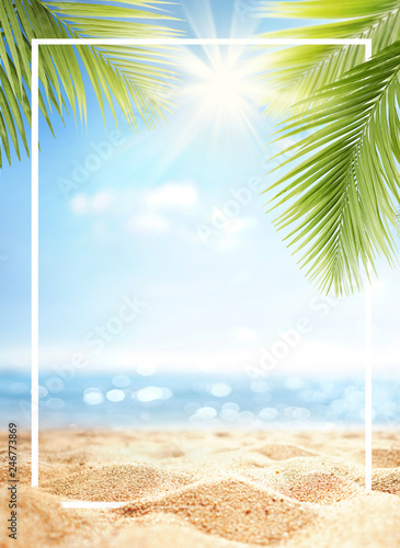 Summer background with frame, nature of tropical golden beach with rays of sun light and leaf palm. Golden sand beach close-up, sea, blue sky, white clouds. Copy space, summer vacation concept.