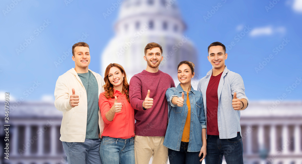 friendship and people concept - group of smiling friends showing thumbs up over capitol building background