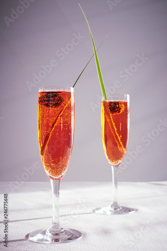 two spriz drinks with green leaf decoration in a flute crystal glass photo