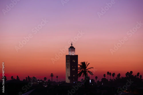 Fototapeta Naklejka Na Ścianę i Meble -  Beautiful sunset in Marrakech, Morocco. Silhouette of oriental architecture minaret tower in front of colorful purple creamy sky