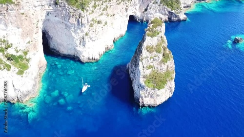 Aerial drone bird's eye view video of tropical rocky bay of Ortholithos with famous cave of Papanikolis and turquoise calm waters forming a blue lagoon photo