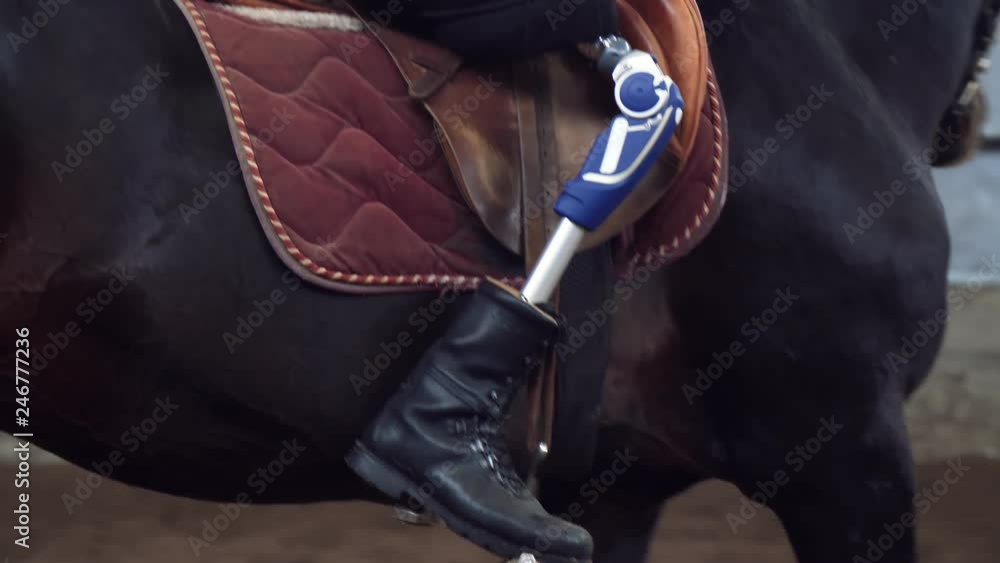 Slide Rider Handicapped Device close-up, artificial leg, limb in stirrups. male rider, disabled person ...
