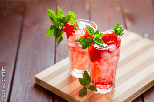 Sparkling pink strawberry lemonade on dark wooden background