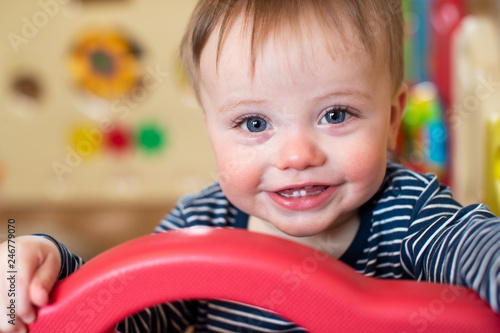 Portrait Of Cute Baby Boy Looking Out Of Play Pen And Smiling At Camera