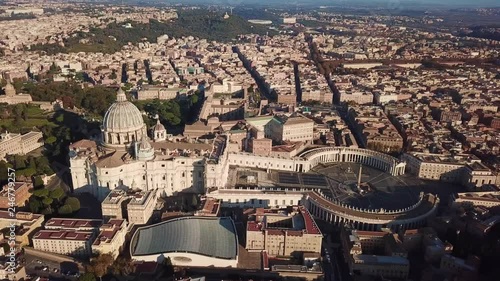 Aerial drone video of Saint Peter's square in front of world's largest church - Papal Basilica of St. Peter's, Vatican - an elliptical esplanade created in the mid seventeenth century, Rome, Italy photo