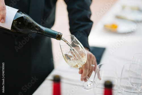 Photography Unrecognizable waiter serving a glass of white wine
