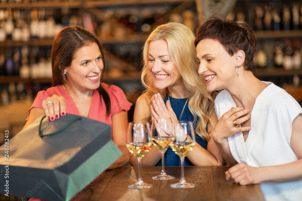 people, leisure and lifestyle concept - women with shopping bag at wine bar or restaurant