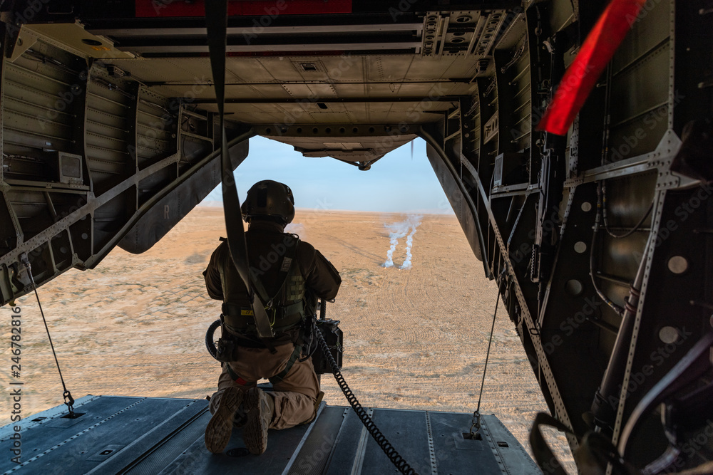 Fototapeta premium Soldat mit Bordwaffe in einem Bundeswehr Hubschrauber über Afghanistan