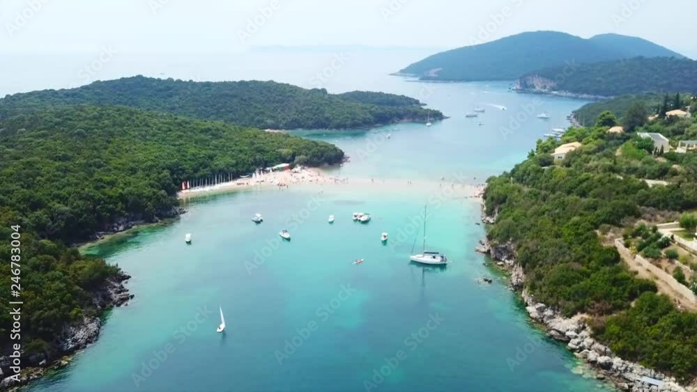 Aerial drone bird's eye view video of iconic paradise sandy beach of blue lagoon with deep turquoise clear sea and pine trees in complex island of Mourtos in Sivota area, Ionian, Epirus, Greece Aerial drone bird's eye view video of iconic paradise sandy beach of blue lagoon with deep turquoise clear sea and pine trees in complex island of Mourtos in Sivota area, Ionian, Epirus, Greece
