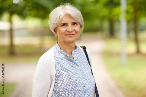 old age, retirement and people concept - portrait of happy senior woman at summer park