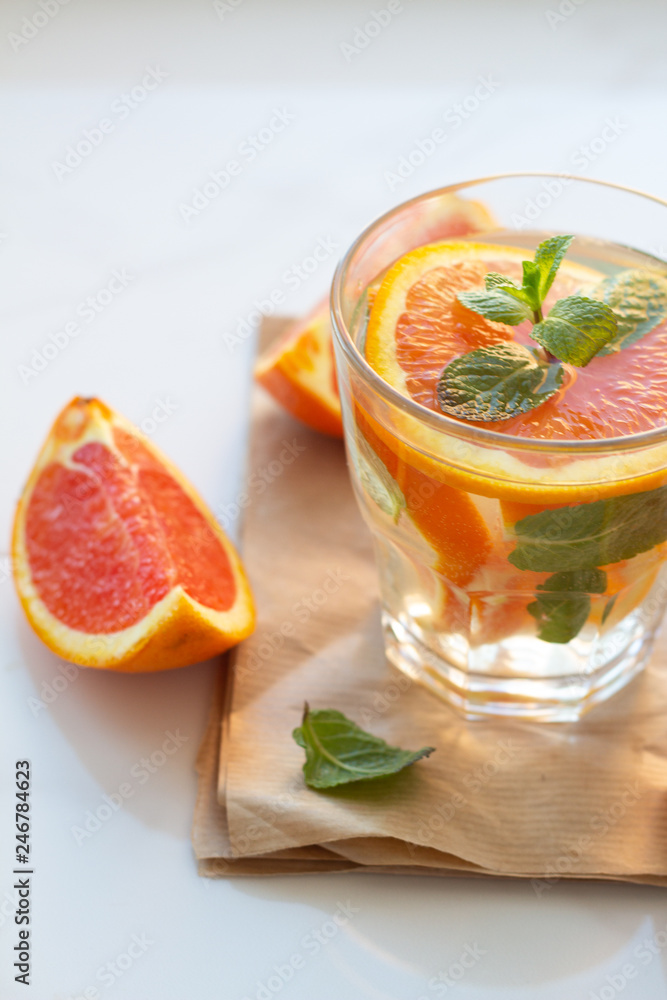 glasses with a refreshing drink with orange and mint leaves on a white background close-up. glasses with a refreshing drink with orange and mint leaves on a white background close-up.