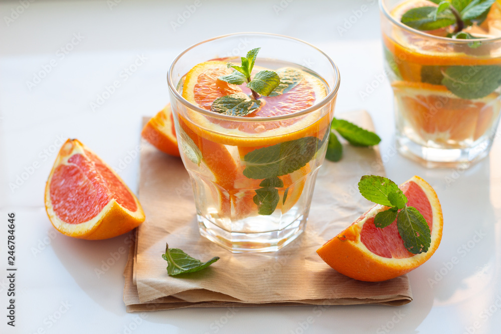 refreshing drink with orange and mint leaves on a napkin on a blom background. refreshing drink with orange and mint leaves on a napkin on a blom background.