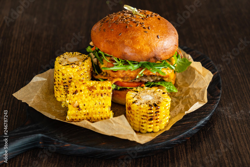 Delicious cheeseburger with corn on the black pan photo