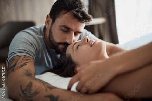 Sexy men and woman being intimate in bed.