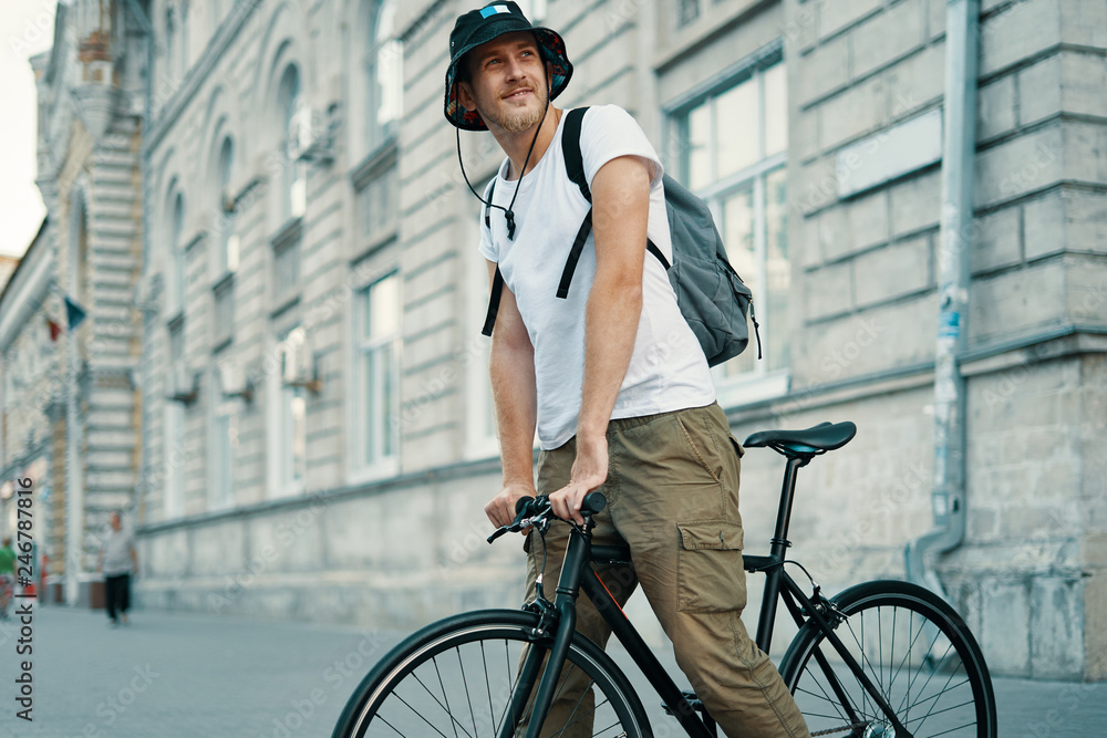 A man riding a bike in an old European city outdoors