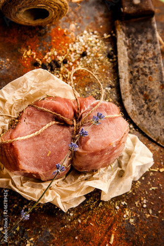 Raw fresh lamb meat and cleaver on dark background