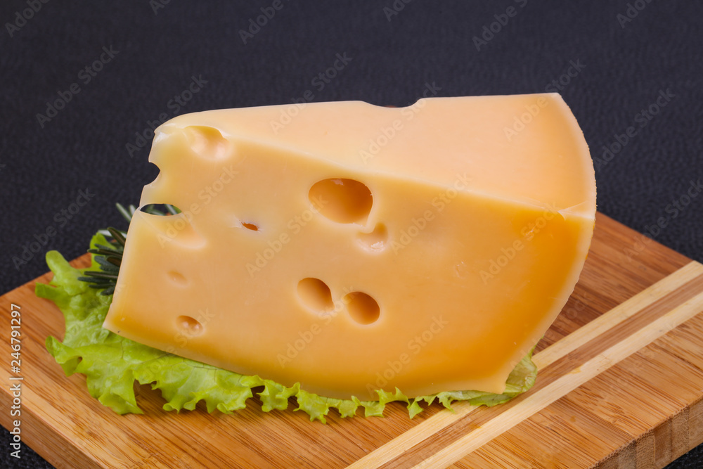 Maasdam cheese in the board served salad leaves Maasdam cheese in the board served salad leaves