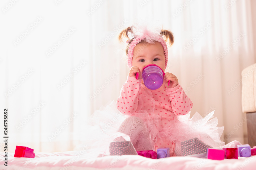 Baby girl drinking water from a bottle Baby girl drinking water from a bottle