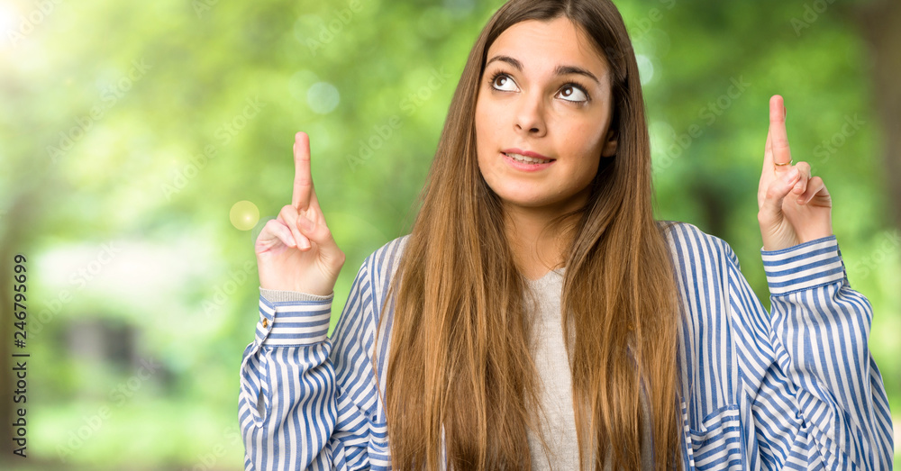 Young girl with striped shirt with fingers crossing and wishing the best at outdoors Young girl with striped shirt with fingers crossing and wishing the best at outdoors