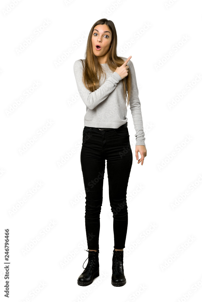Full-length shot of young girl surprised and pointing side on isolated white background Full-length shot of young girl surprised and pointing side on isolated white background