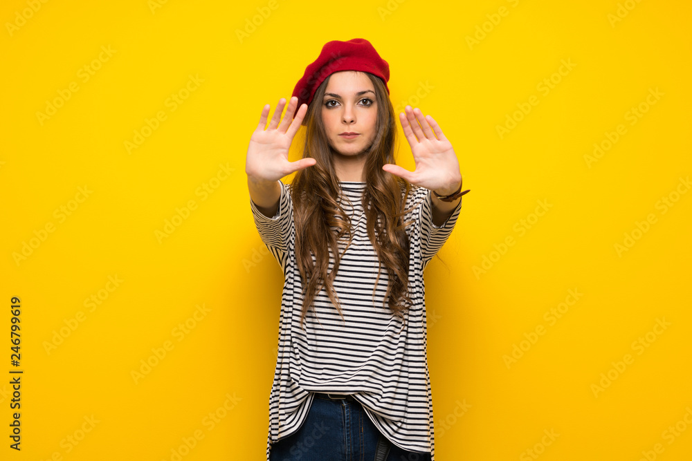 Girl with french style over yellow wall making stop gesture for disappointed with an opinion Girl with french style over yellow wall making stop gesture for disappointed with an opinion