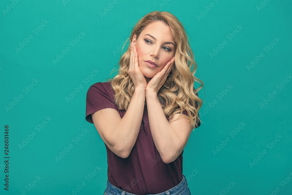 Young attractive blonde on a blue background. Beautiful woman posing on trendy background dressed in fashionable youth clothes. Young attractive blonde on a blue background. Beautiful woman posing on trendy background dressed in fashionable youth clothes.