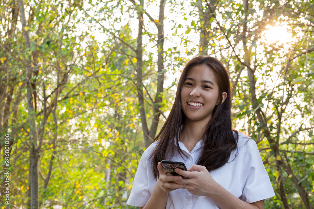 Portrait asian college woman using cell phone with beautiful smiling.